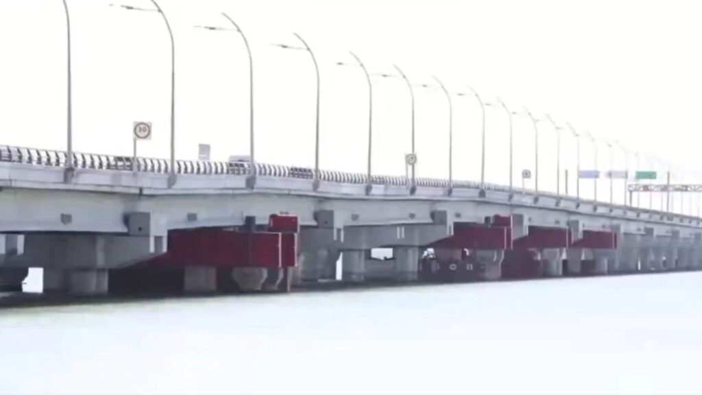 Puente Nichipté en Cancún con apuntalamientos visibles de color rojo entre pilotes sobre el océano.